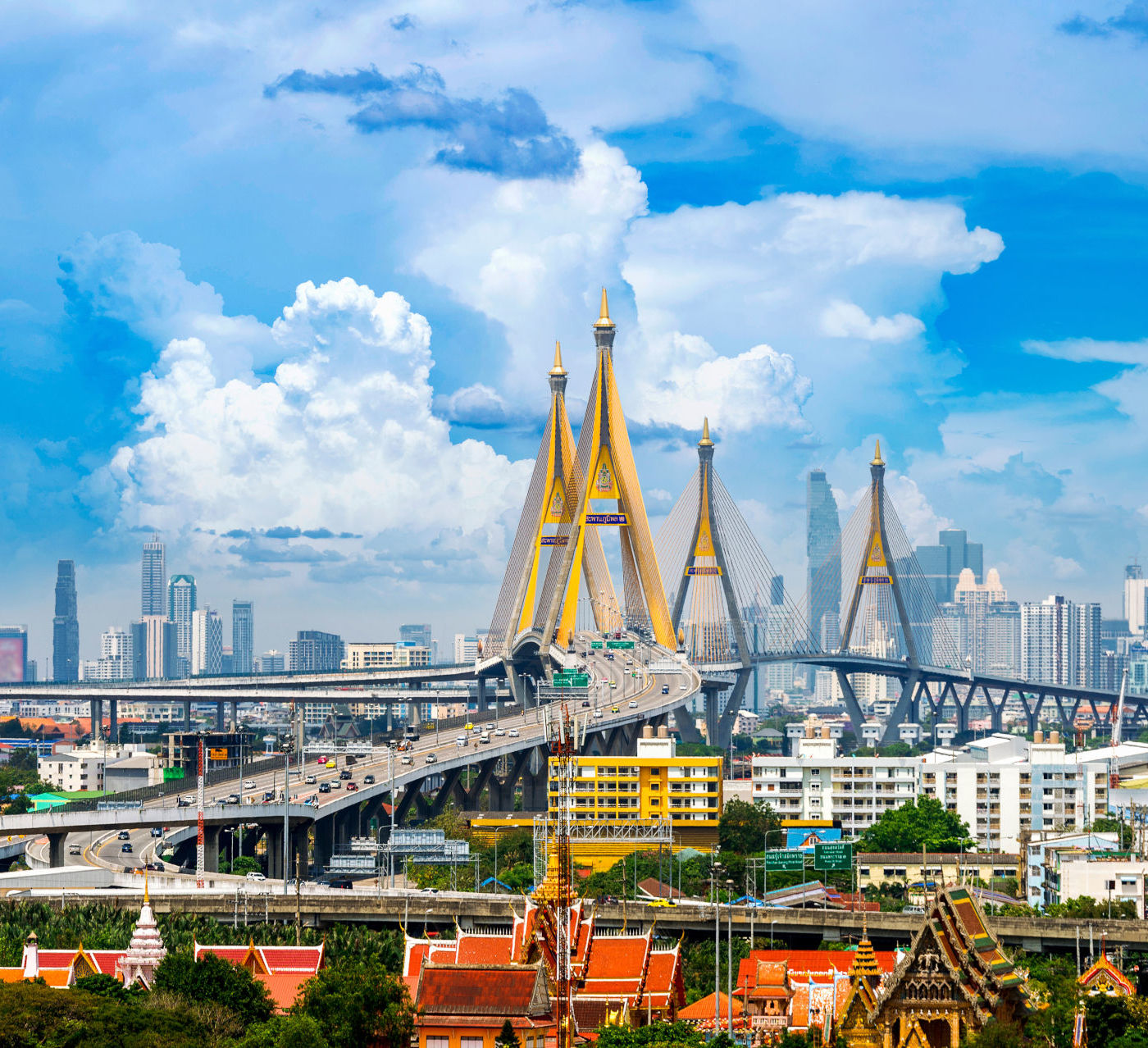 Iconic Bhumibol Bridge, also known as the Industrial Ring Road Bridge, in Bangkok, Thailand, under a blue sky with fluffy clouds