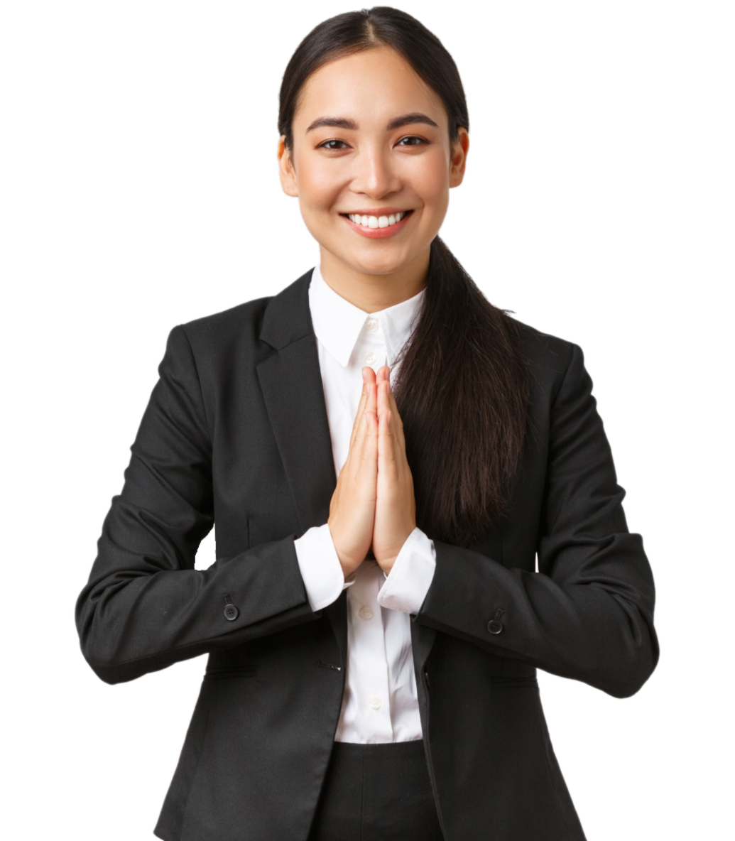 A professional woman in a black suit with a white shirt smiling and greeting with a traditional Thai wai gesture