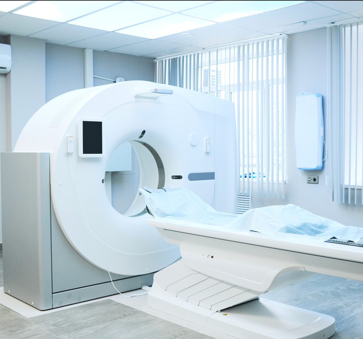 Modern MRI machine in a medical imaging room with a bed prepared for a patient